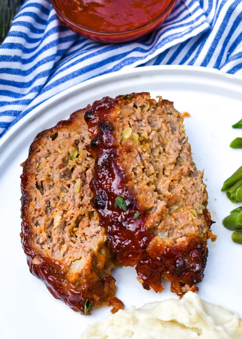 two slices of air fryer meatloaf on a white dinner plate