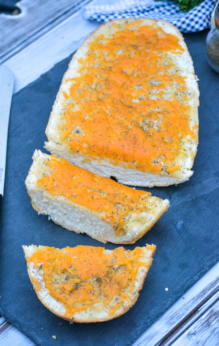 a sliced loaf of cheesy ranch bread on a slate cutting board