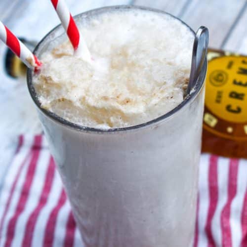 a cream soda float in a glass jar with two red striped paper straws