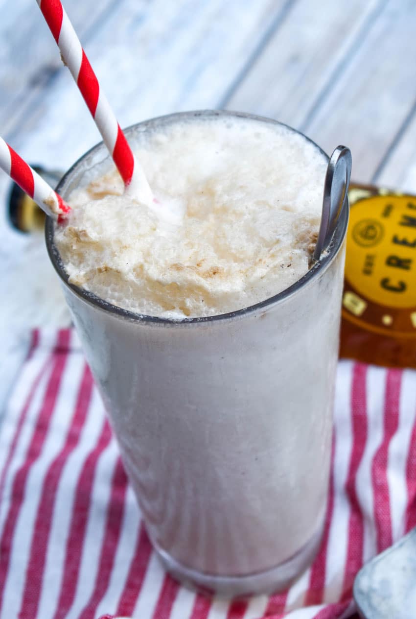 a cream soda float in a glass jar with two red striped paper straws