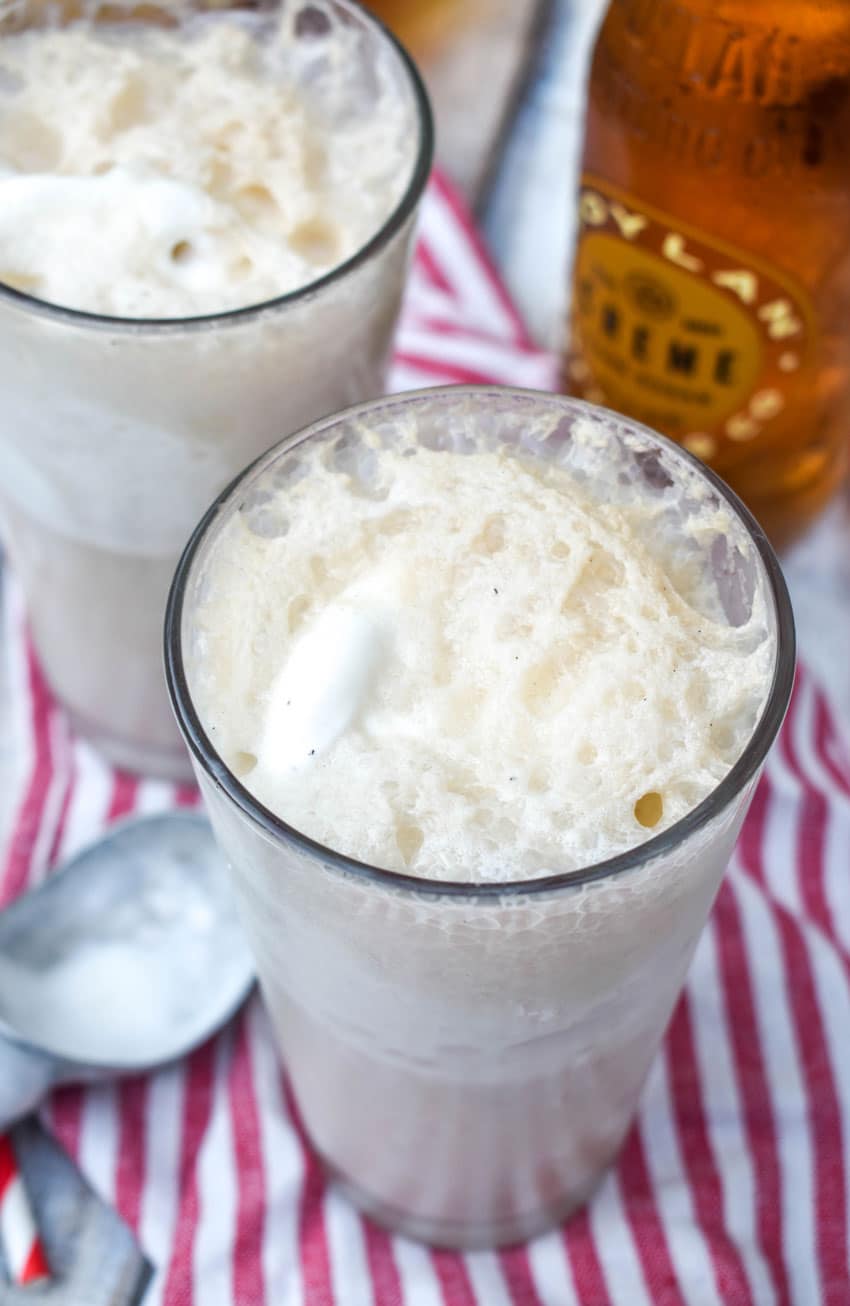 two glasses filled with frothy cream soda ice cream floats