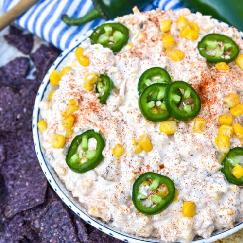 elote corn dip in a white bowl surrounded by tortilla chips