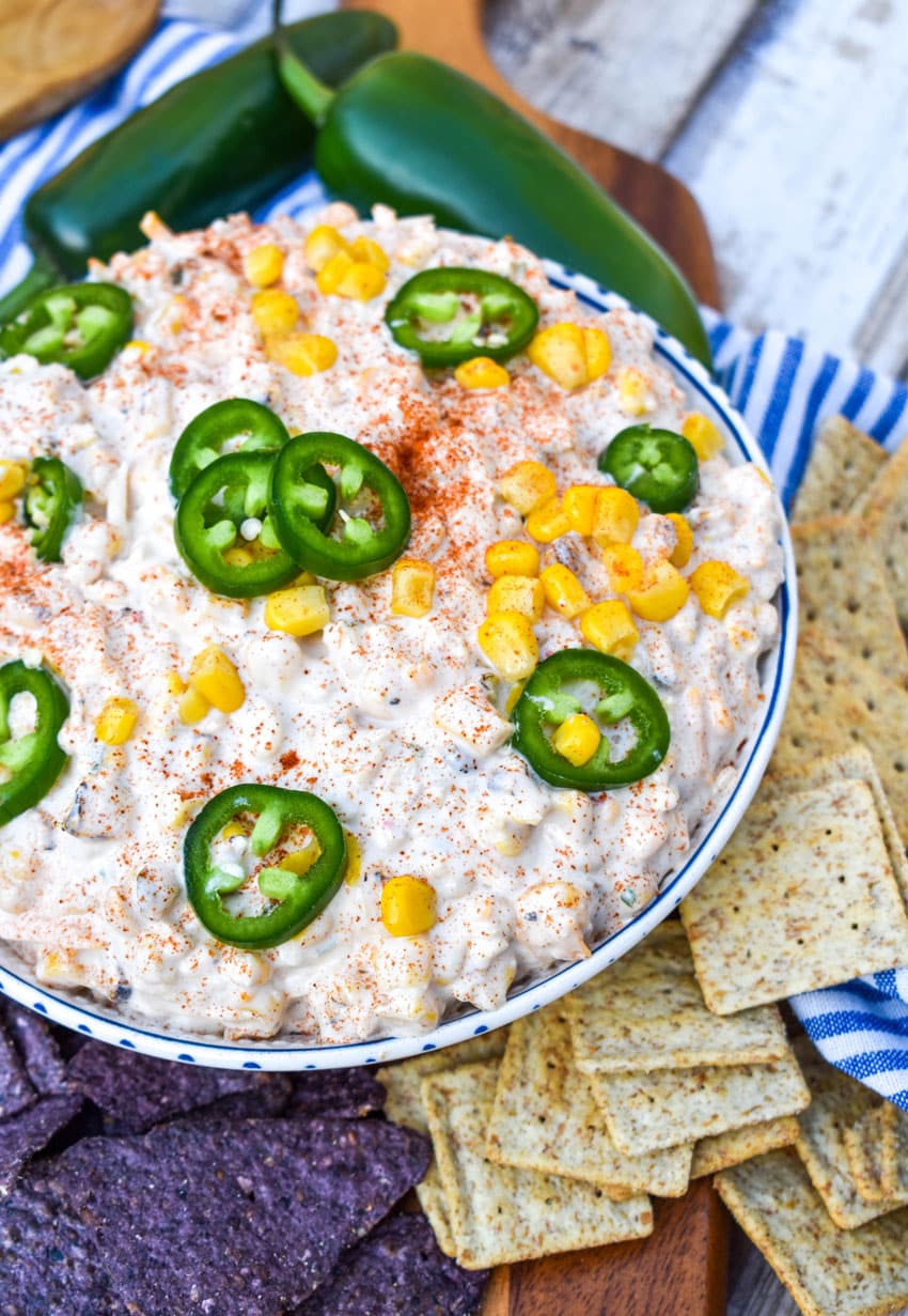 elote corn dip in a white bowl surrounded by tortilla chips