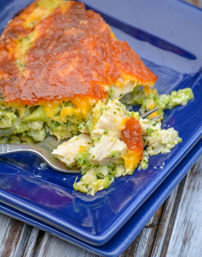 a slice of cheesy chicken and broccoli pie on a blue plate