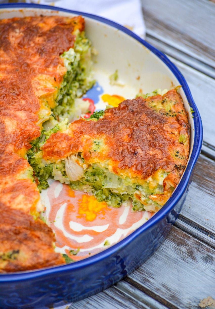 a slice of cheesy chicken and broccoli pie in a blue pie dish