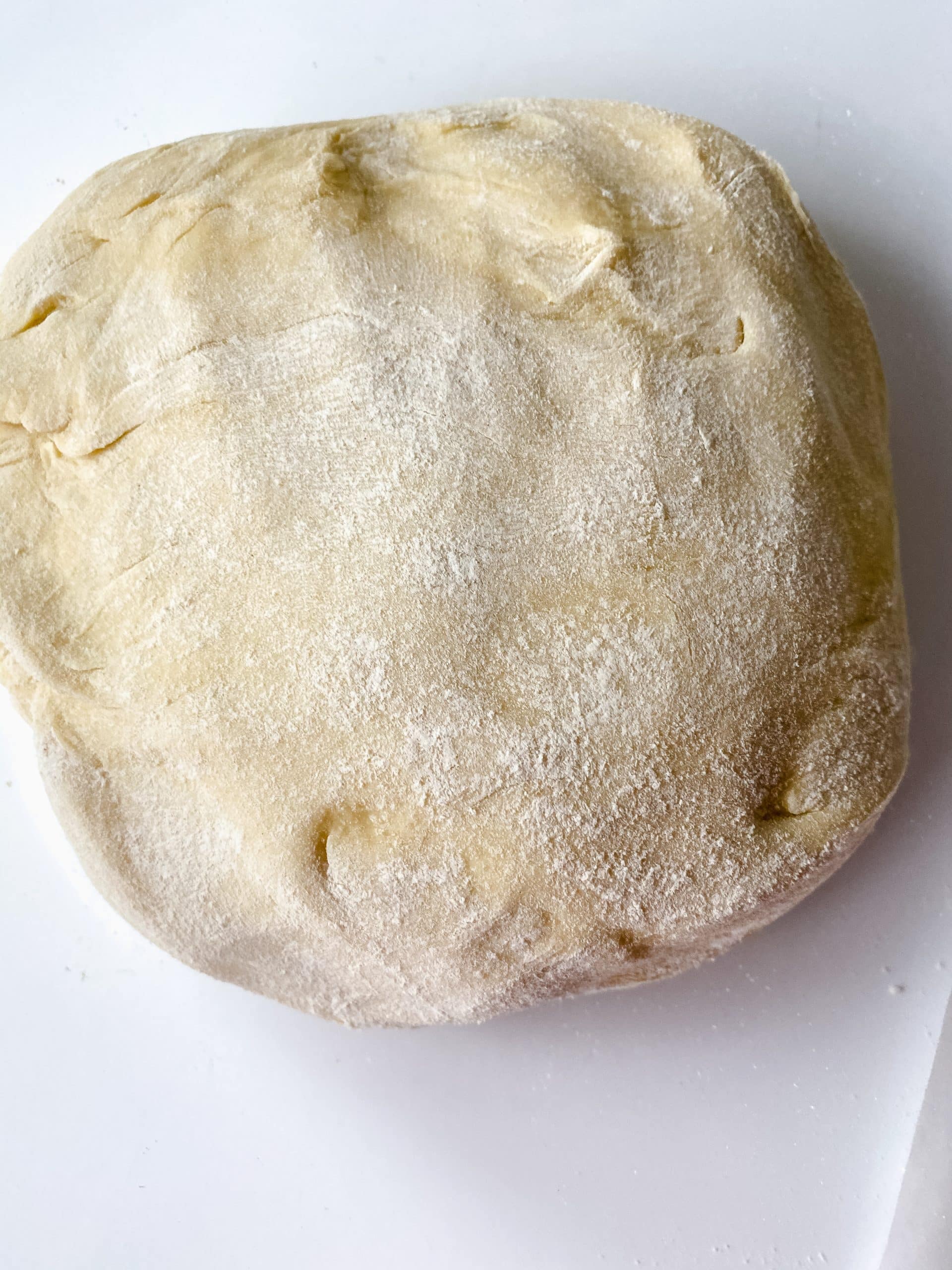 a round lump of homemade danish dough on a floured counter top
