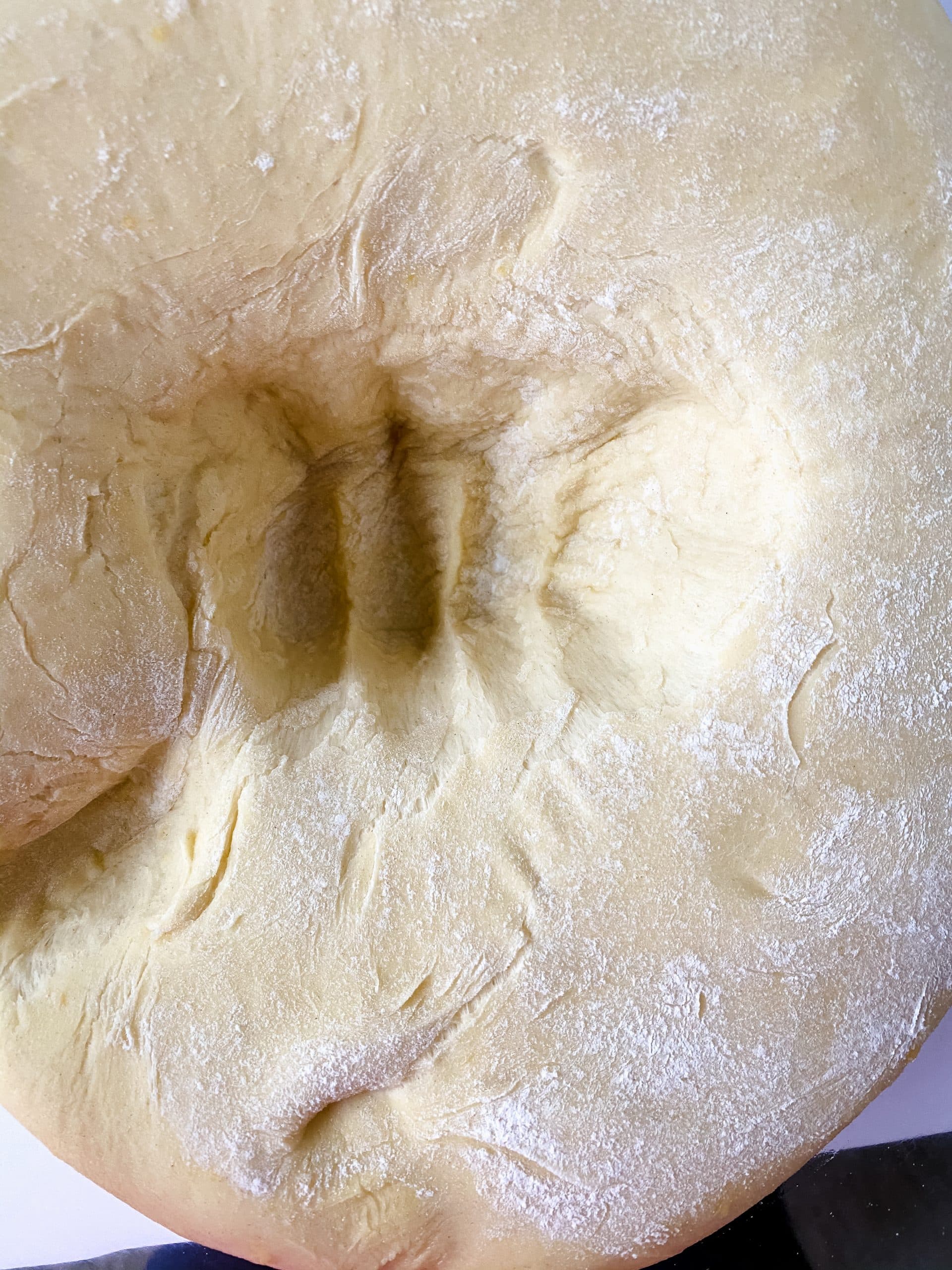 punched down pastry dough in a large mixing bowl