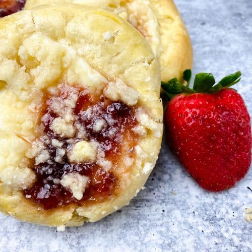 two homemade strawberry cream cheese danish next to fresh berries
