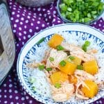 instant pot pineapple chicken over steamed white rice in a white & blue ceramic bowl