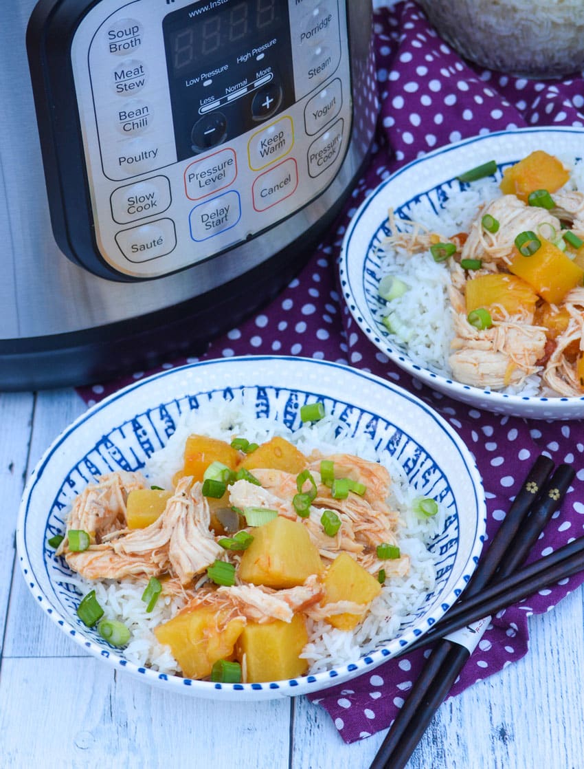two bowls of instant pot pineapple chicken next to a pressure cooker