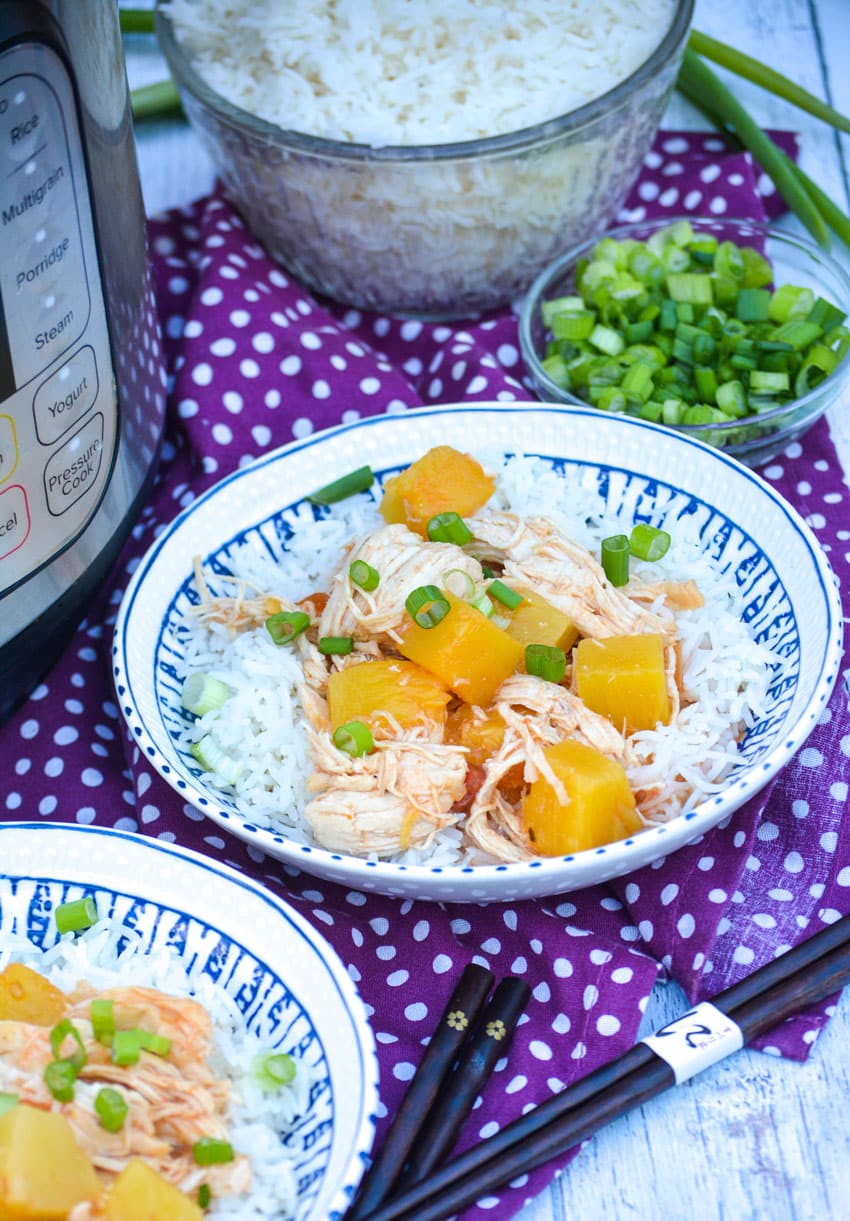 instant pot pineapple chicken over steamed white rice in a white & blue ceramic bowl