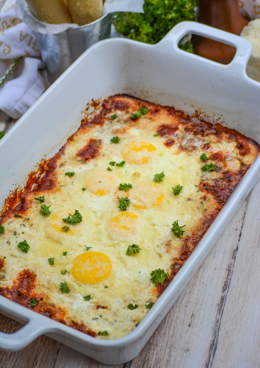Italian baked eggs in a white casserole dish