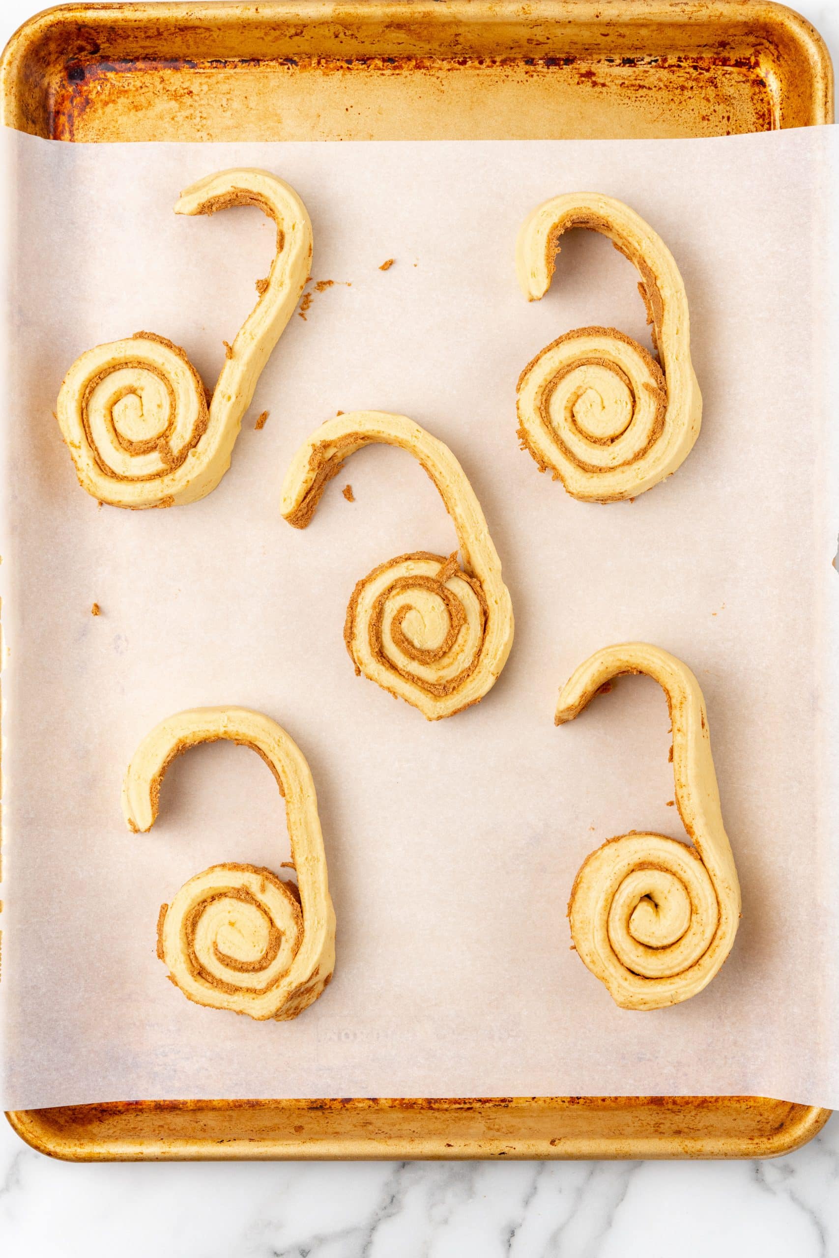 spread apart canned cinnamon rolls on a parchment paper lined baking sheet