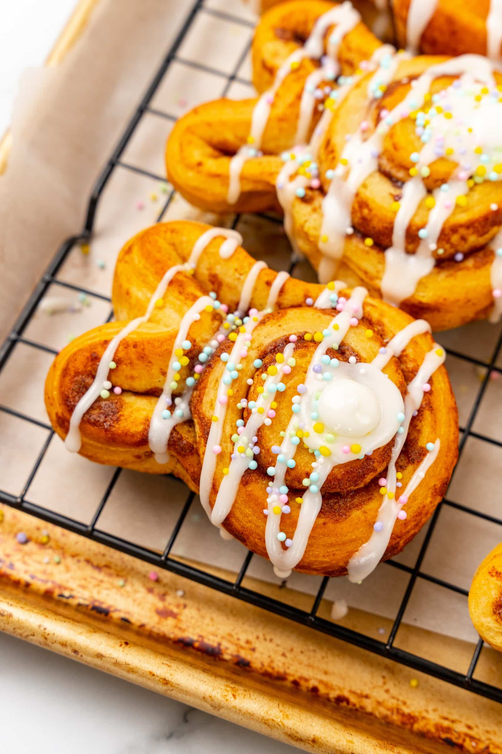 frosted bunny cinnamon rolls on a wire cooling rack