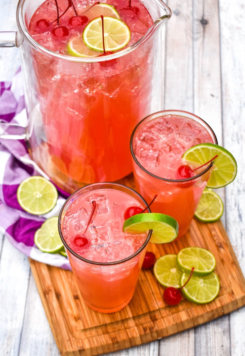 easy cherry limeade in glasses on a wooden cutting board