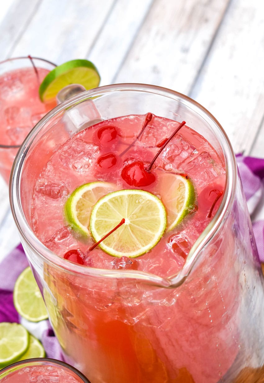 cherry limeade in a large glass pitcher