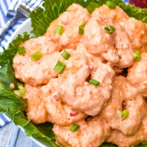 crispy air fryer bang bang shrimp in a lettuce leaf lined white bowl