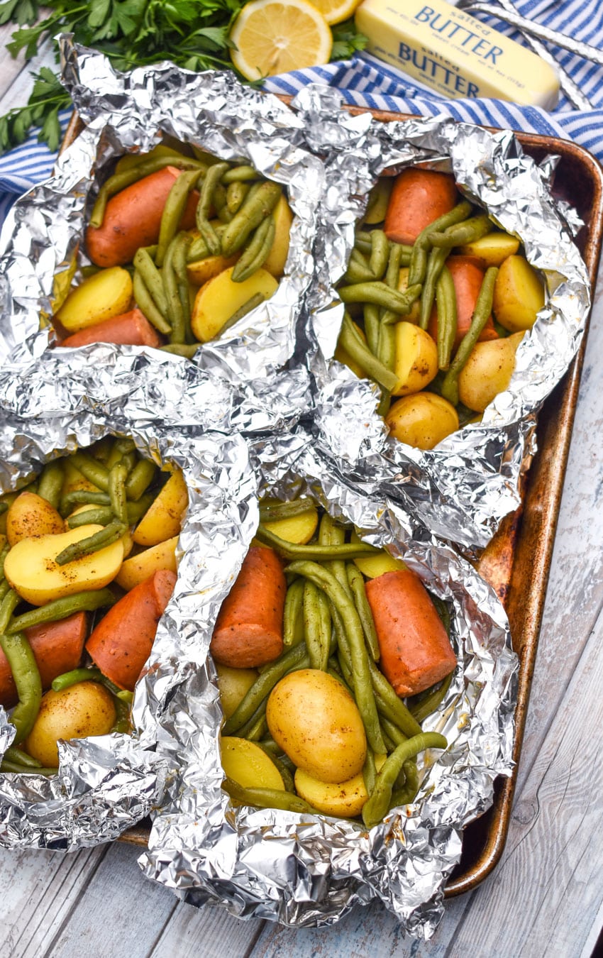 opened Cajun chicken foil packets on a metal baking sheets