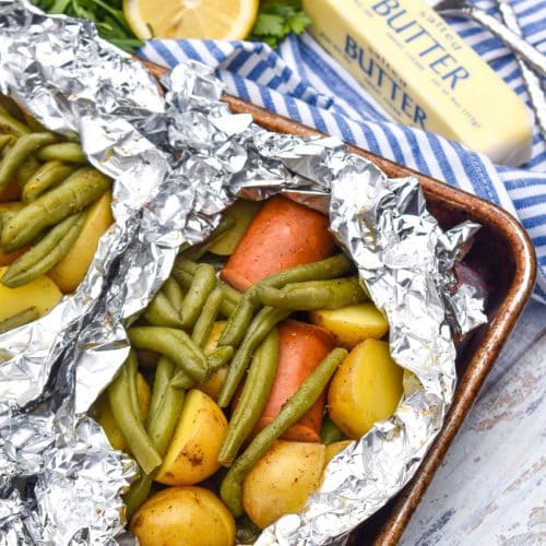 opened Cajun chicken foil packets on a metal baking sheets