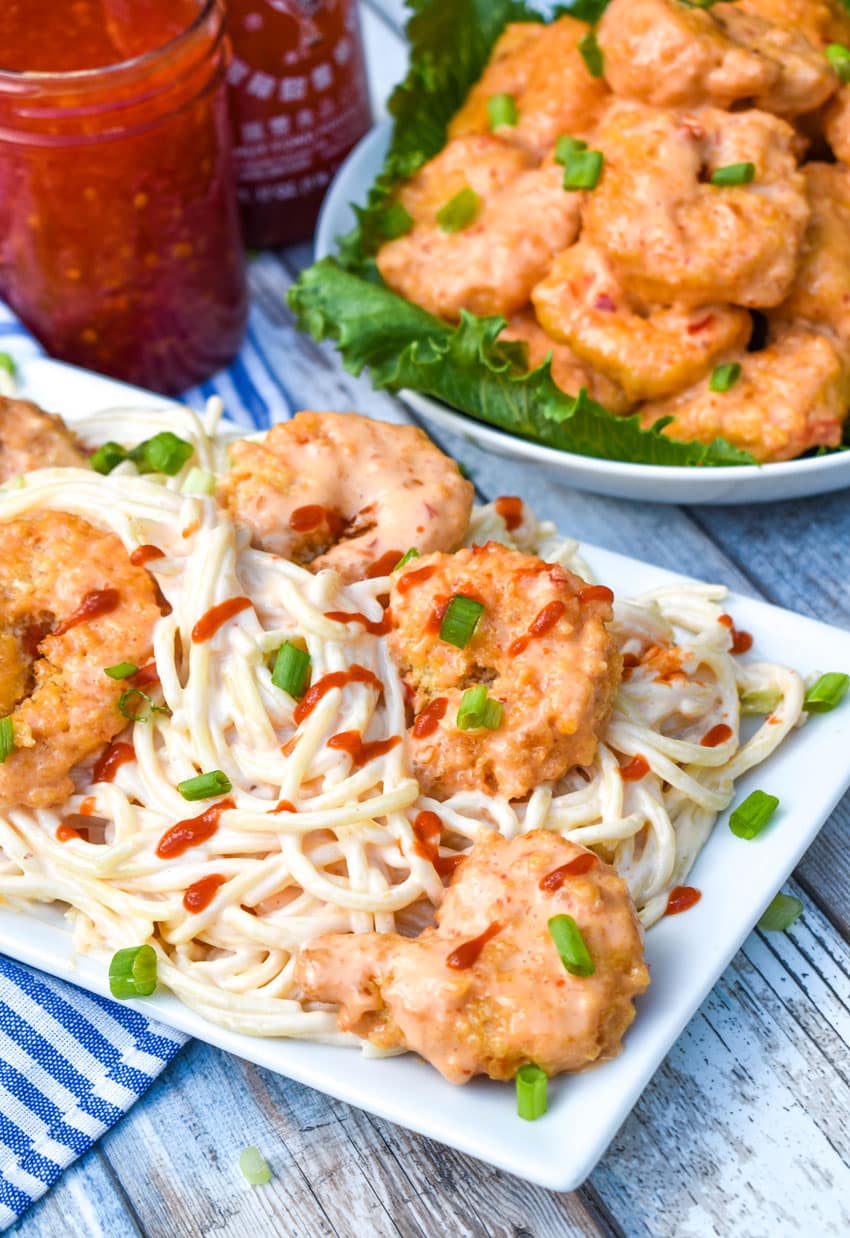 creamy bang bang shrimp pasta on a white serving platter