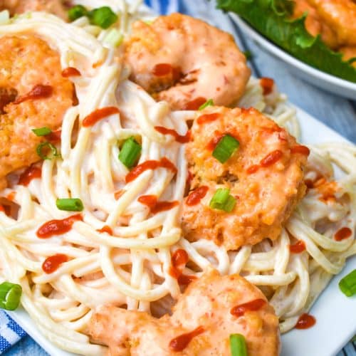 creamy bang bang shrimp pasta on a white serving platter