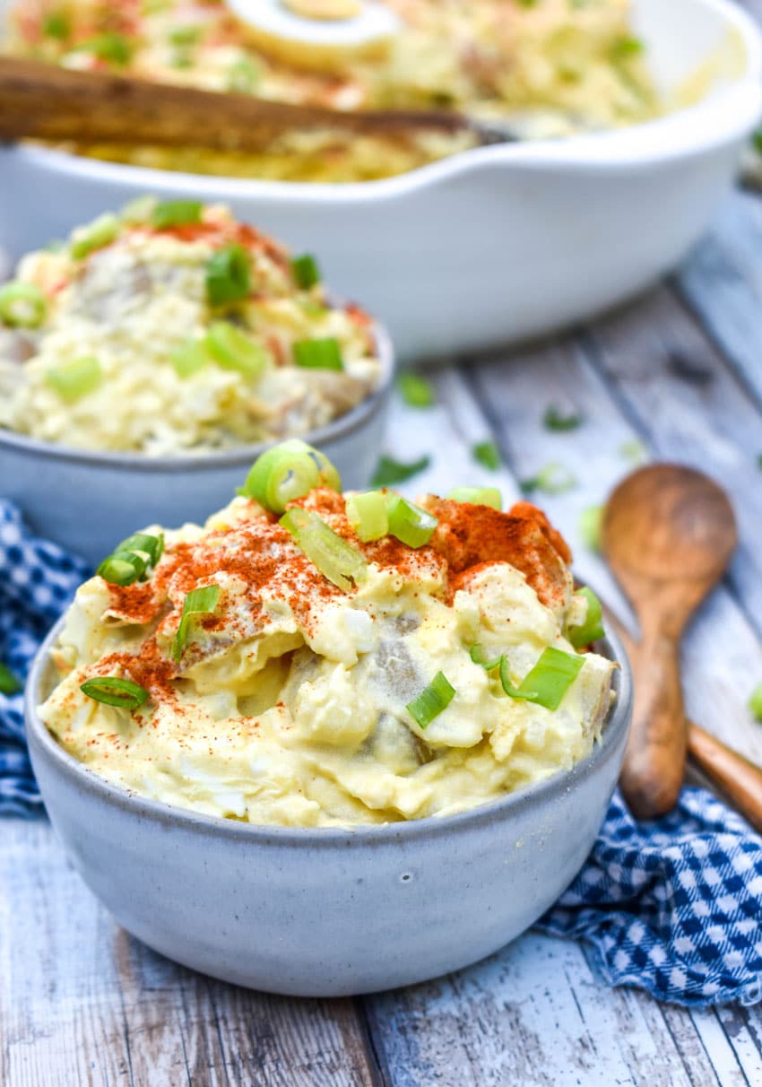 creamy potato salad recipe with egg served in two small gray bowls