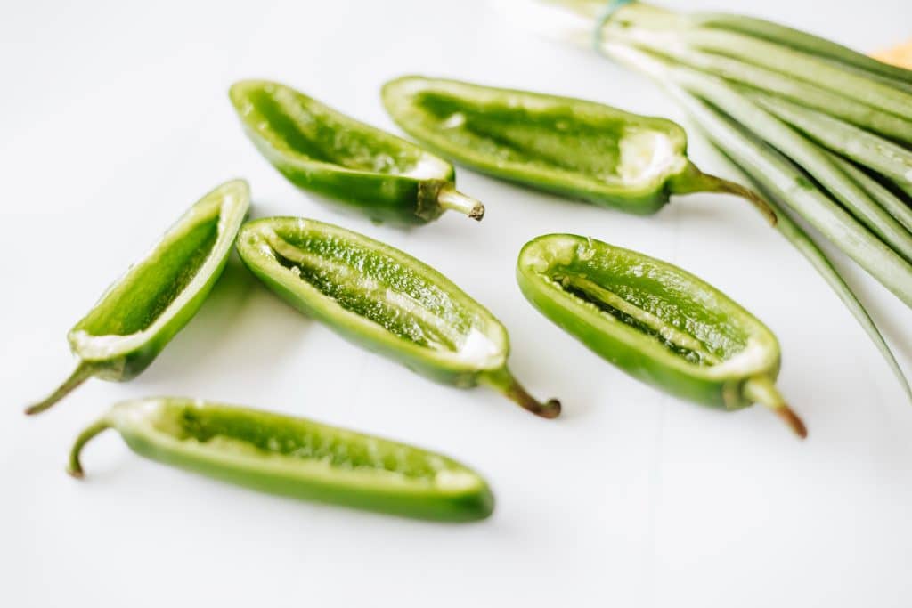 hollowed out jalapeno halves on a white coutnertop