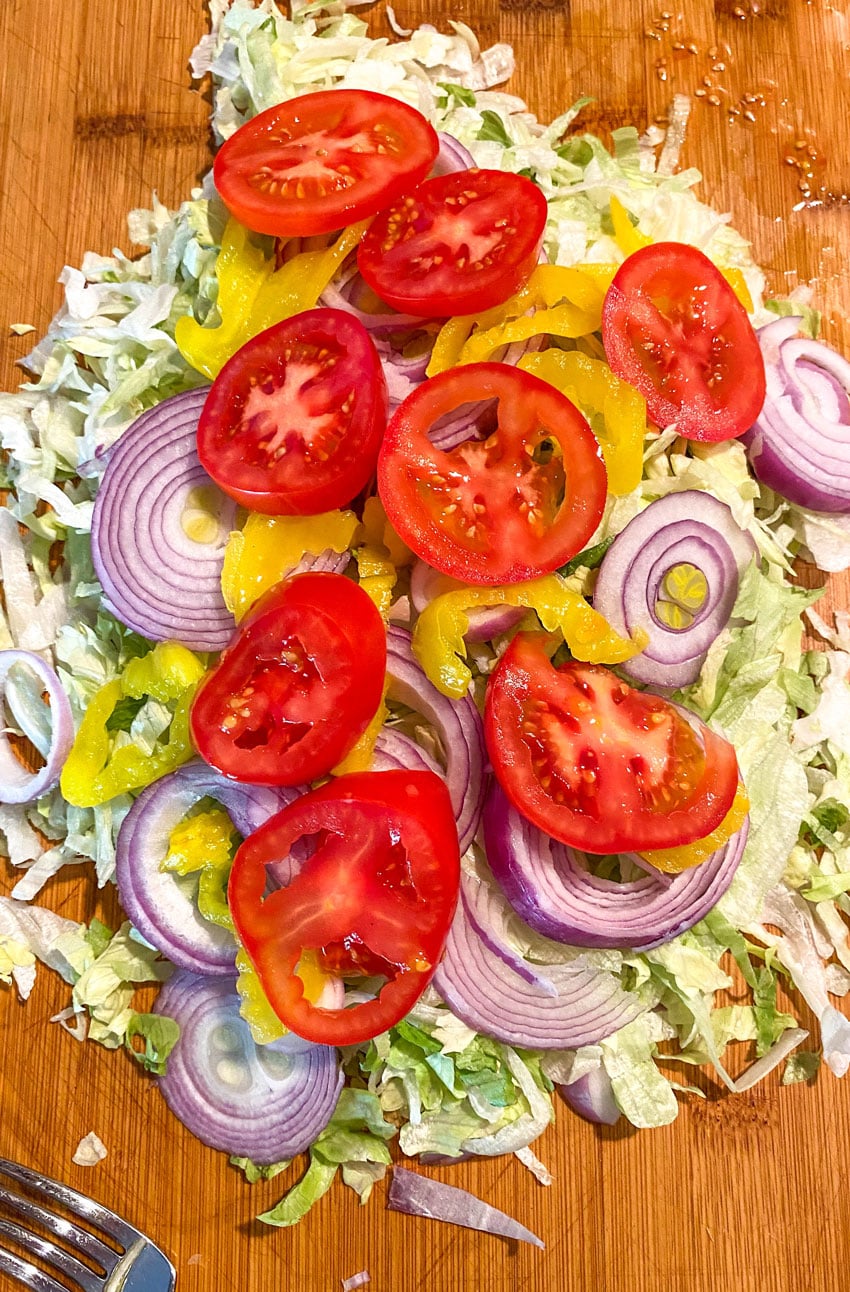 ingredients to make a tiktok chopped italian sandwich on a wooden cutting board