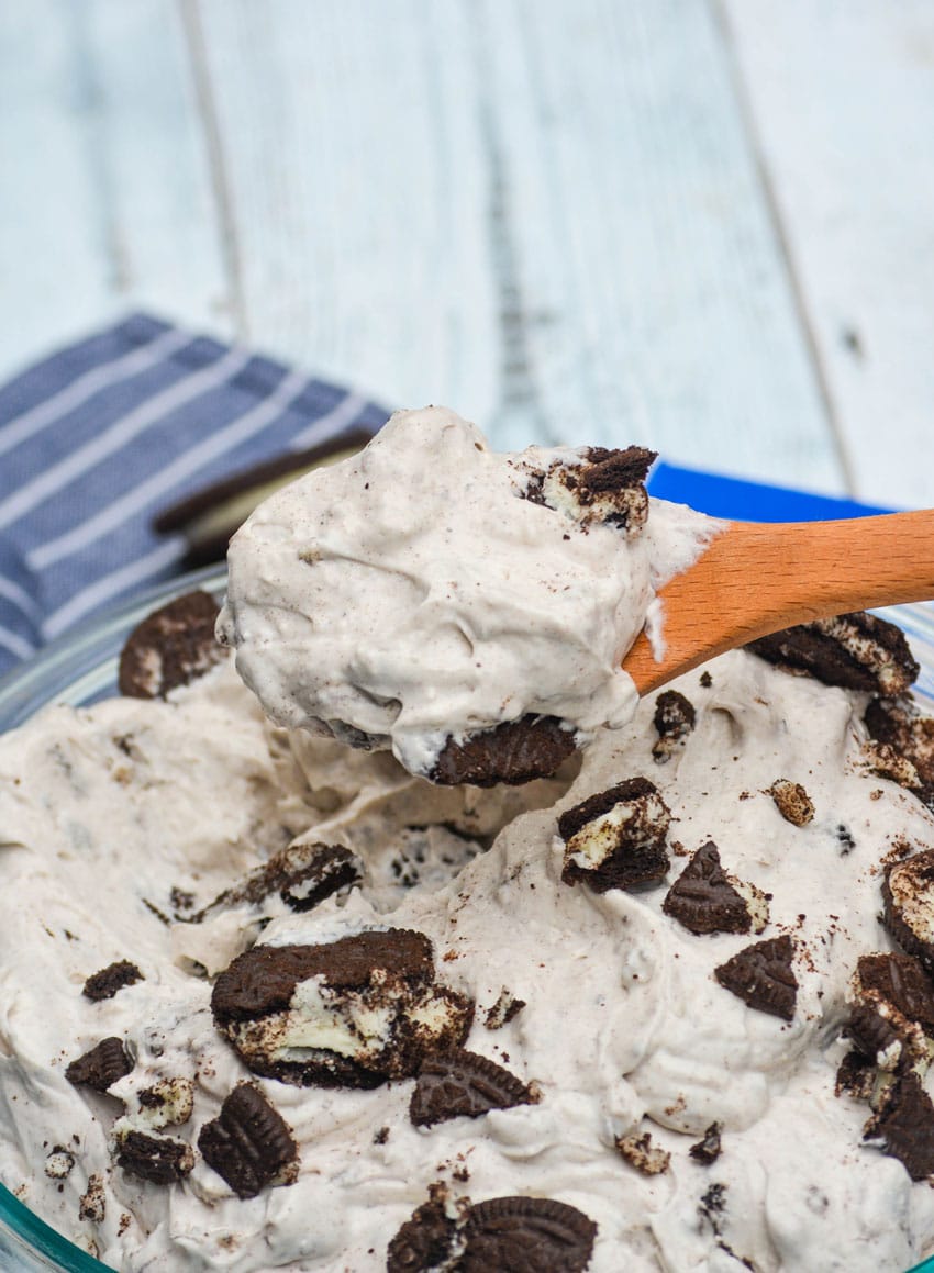 a wooden spoon holding up a scoop of cookies and cream fluff