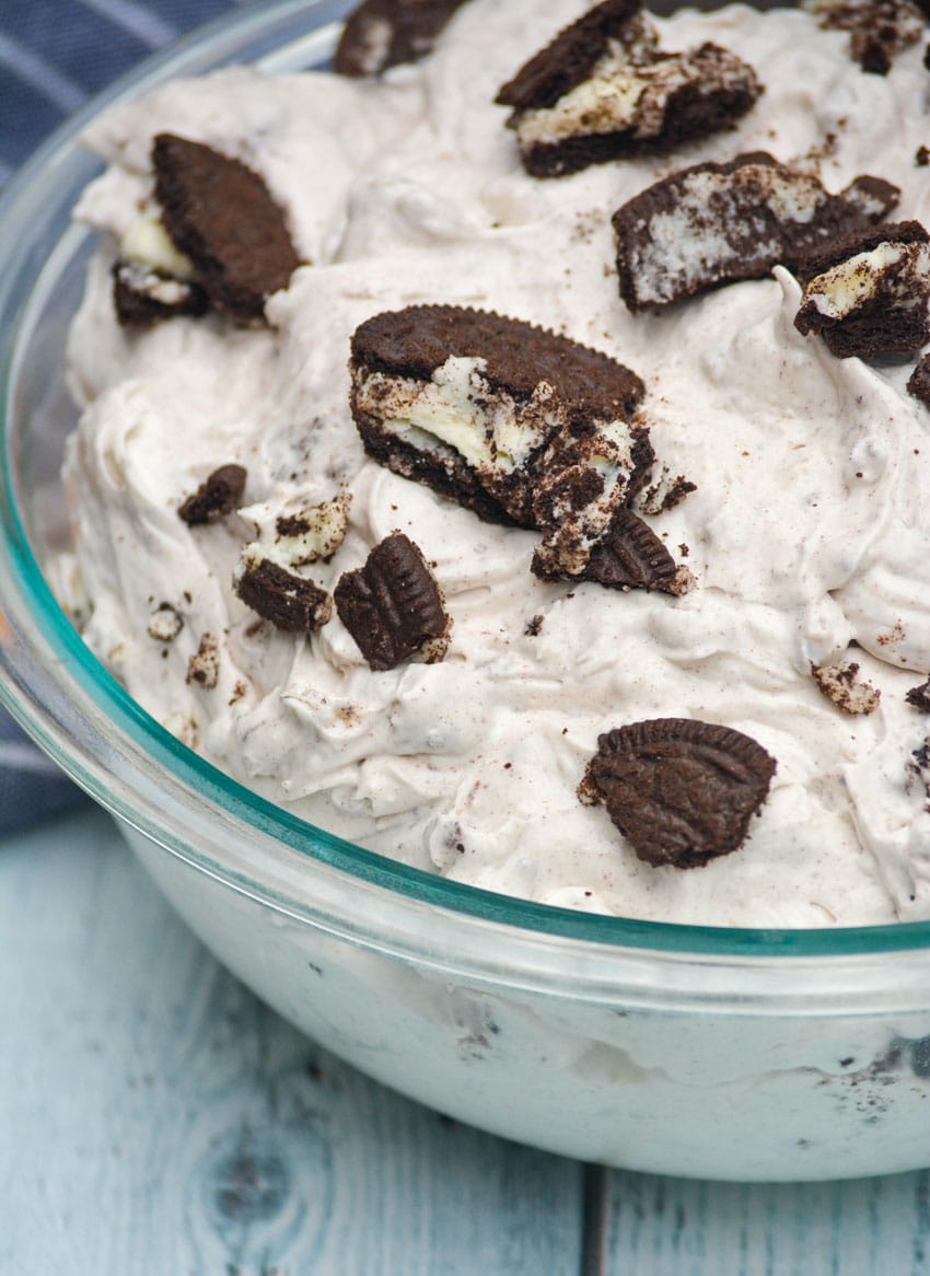 oreo fluff salad topped with crushed sandwich cookies in a large glass bowl
