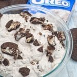 oreo fluff salad in a glass mixing bowl surrounded by oreo sandwich cookies