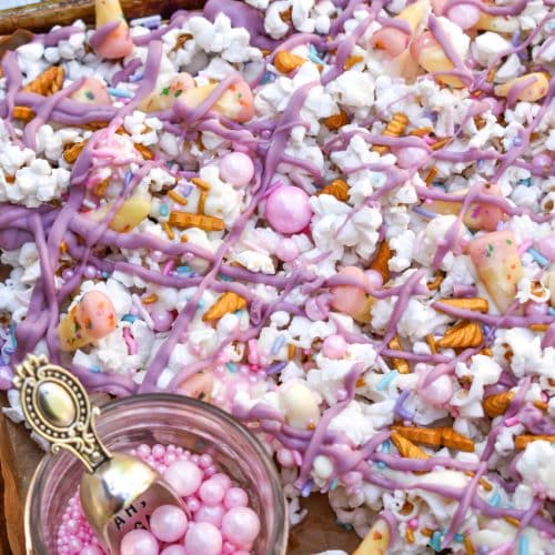unicorn munch popcorn mix on a parchment paper lined baking sheet