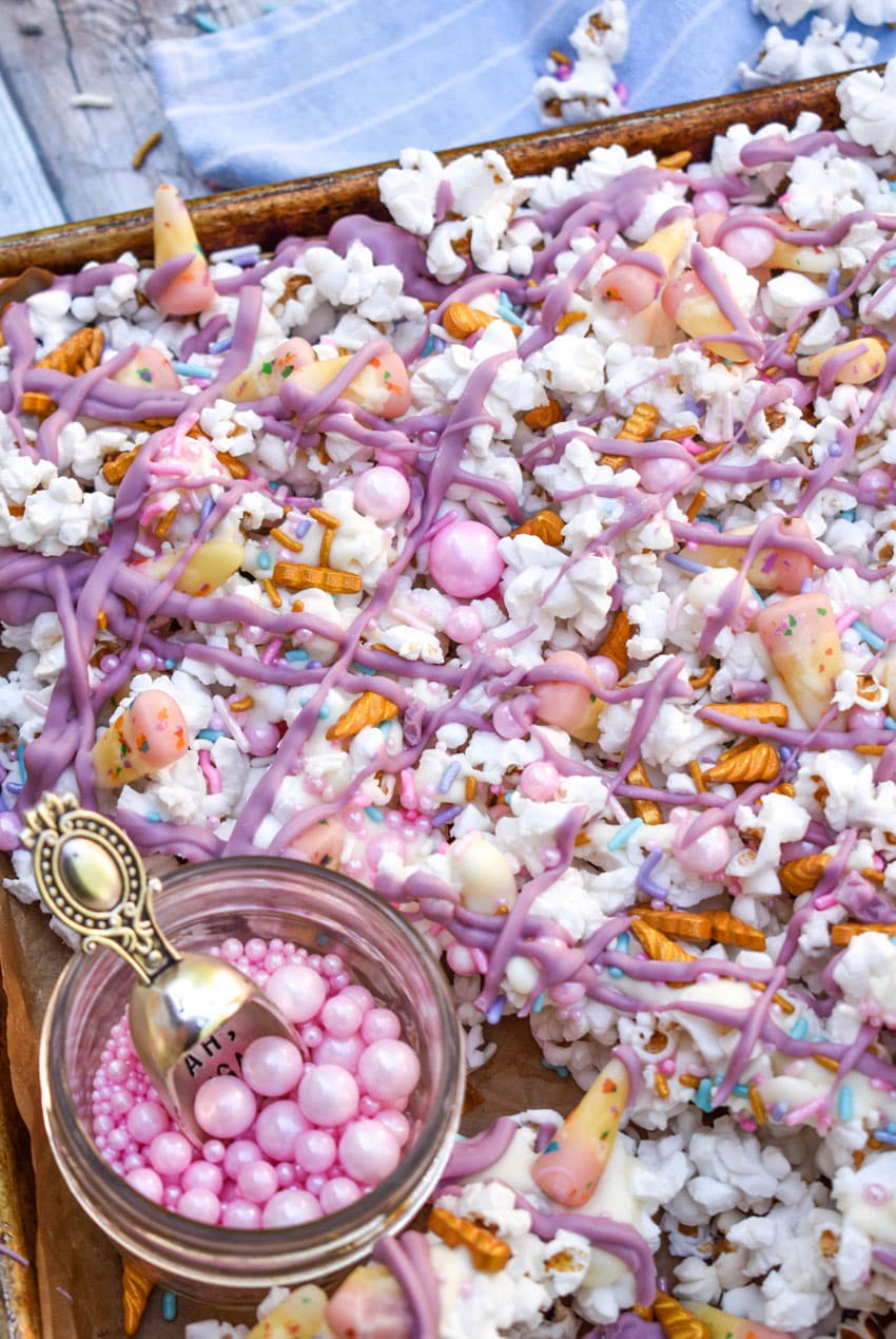 unicorn munch popcorn mix on a parchment paper lined baking sheet