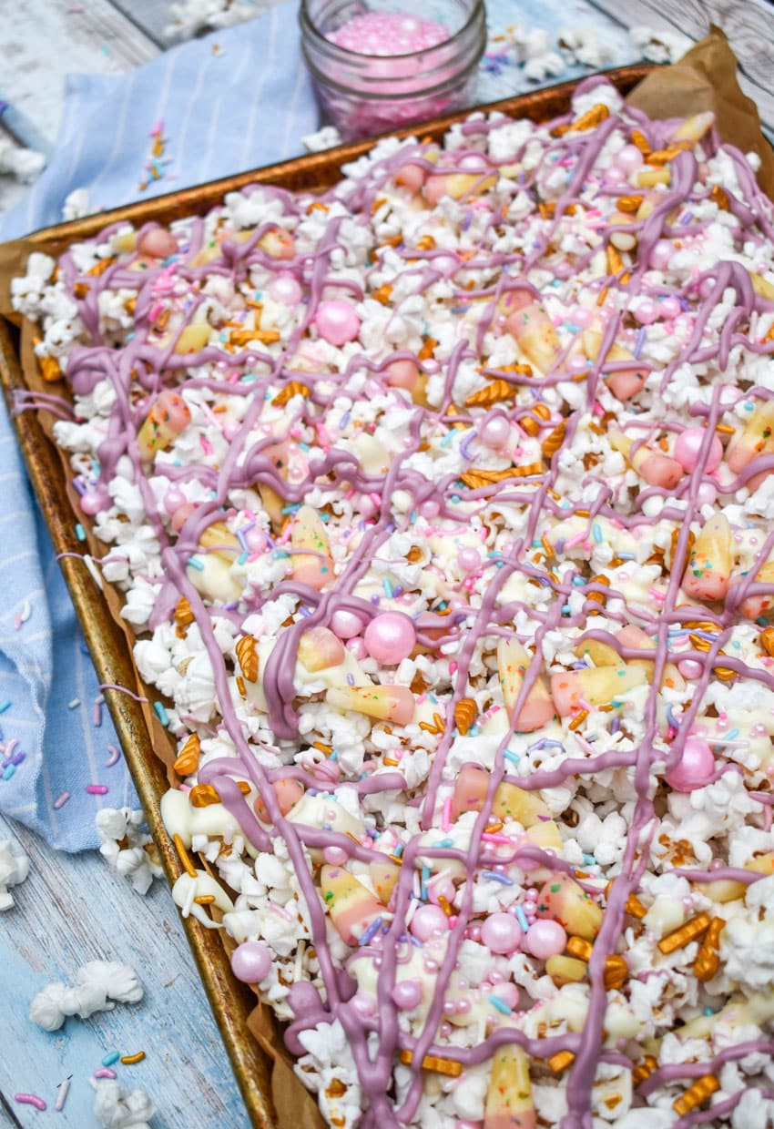 unicorn munch popcorn mix on a parchment paper lined baking sheet