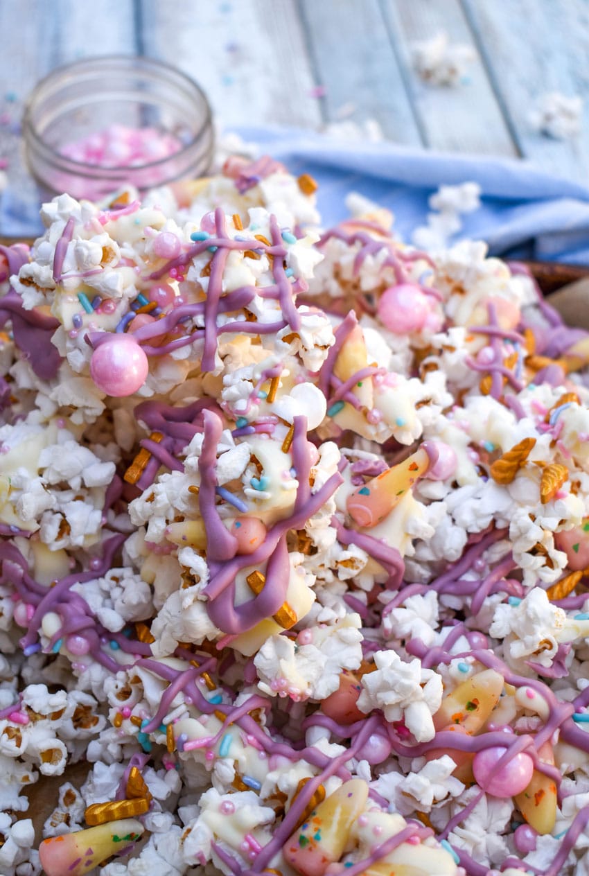 unicorn munch popcorn mix on a parchment paper lined baking sheet