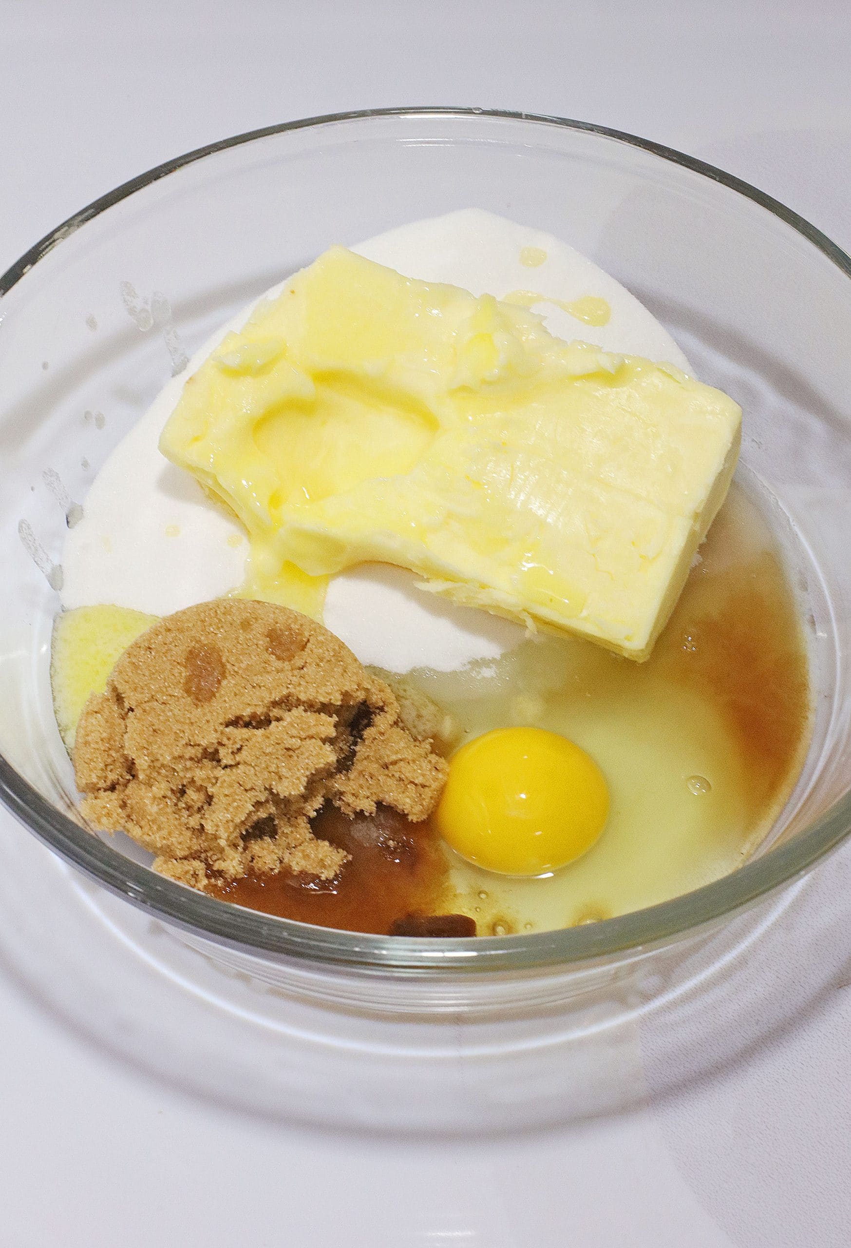 wet ingredients for a cookie cake in a glass mixing bowl