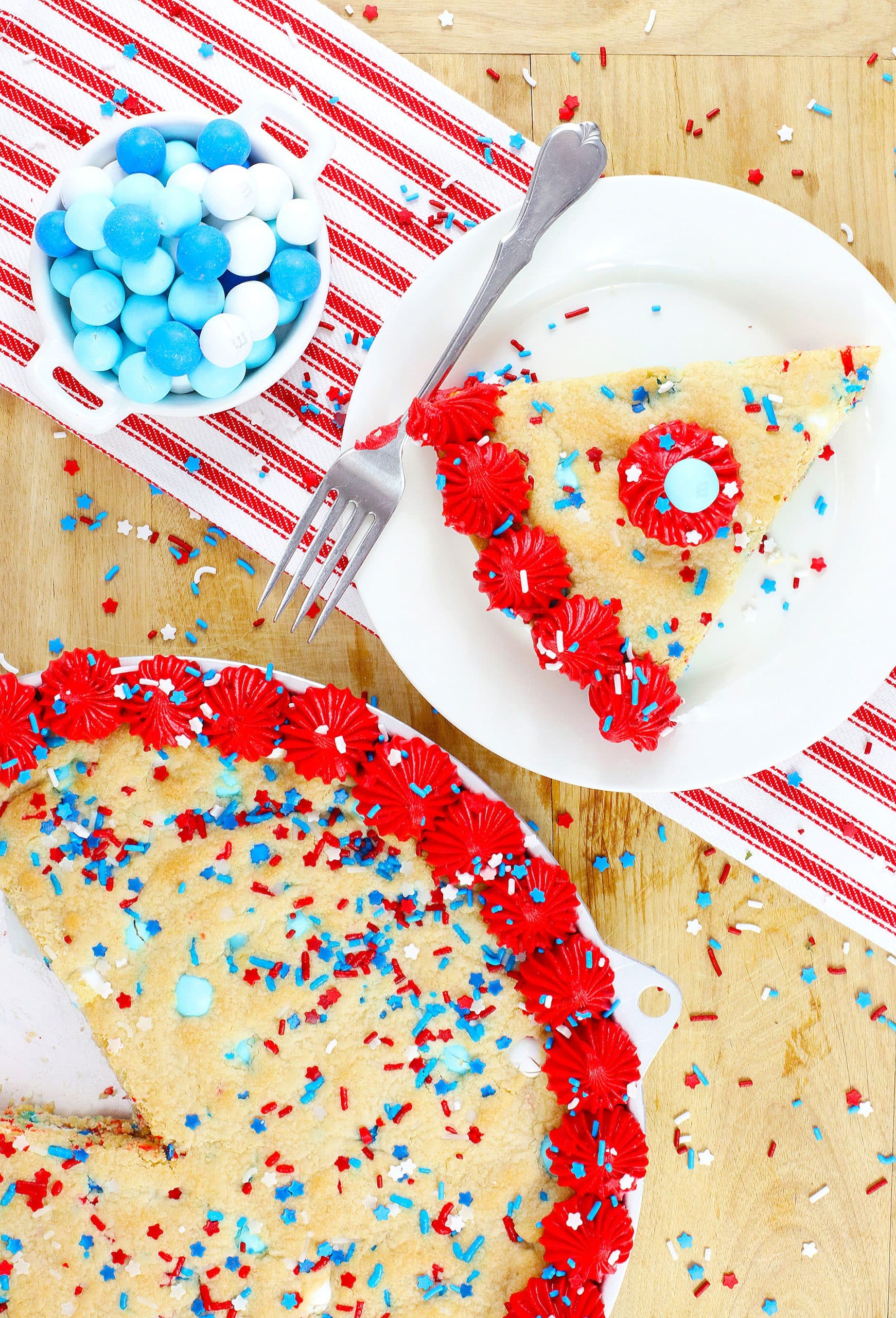 a slice of red white and blue frosted cookie pie on a white plate