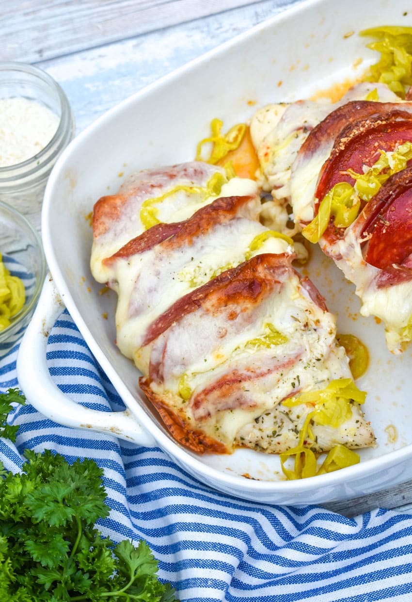 Antipasto hasselback chicken breasts in a white baking dish