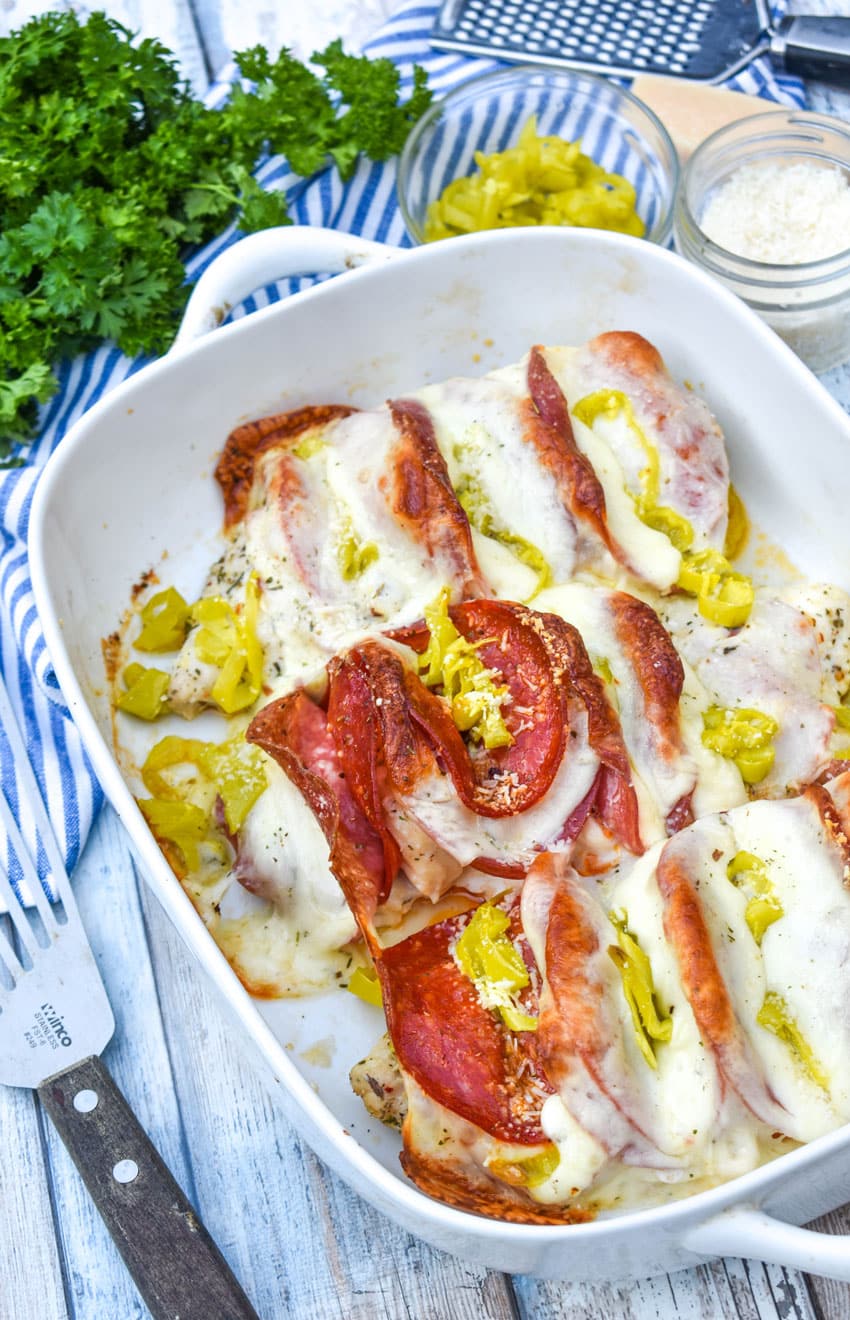 Antipasto hasselback chicken breasts in a white baking dish