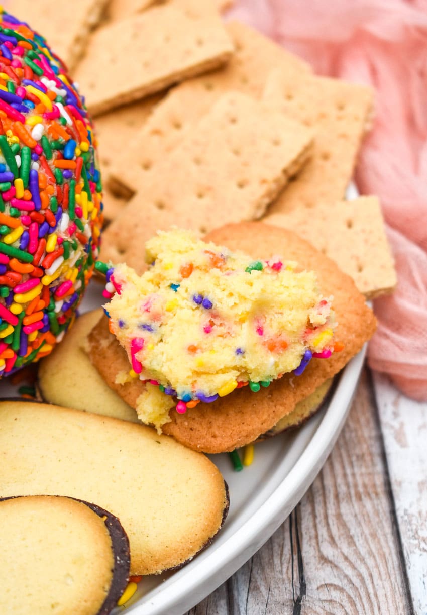 cake batter cheese ball dip spread on a lorna doone cookie resting on a white plate