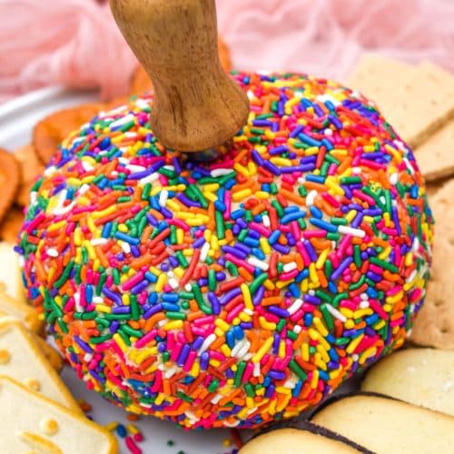 cake batter dessert cheeseball on a white plate surrounded by assorted cookies