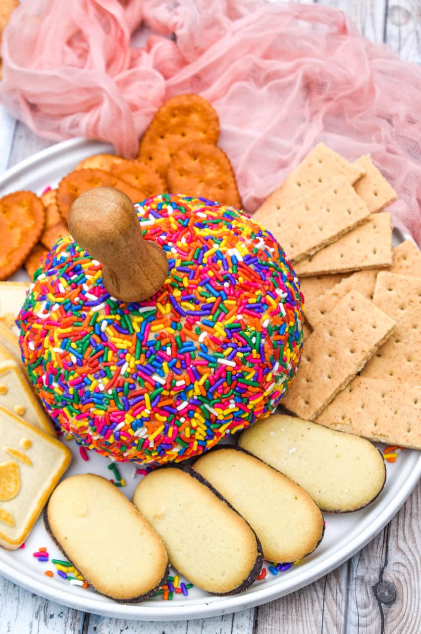 cake batter dessert cheeseball on a white plate surrounded by assorted cookies