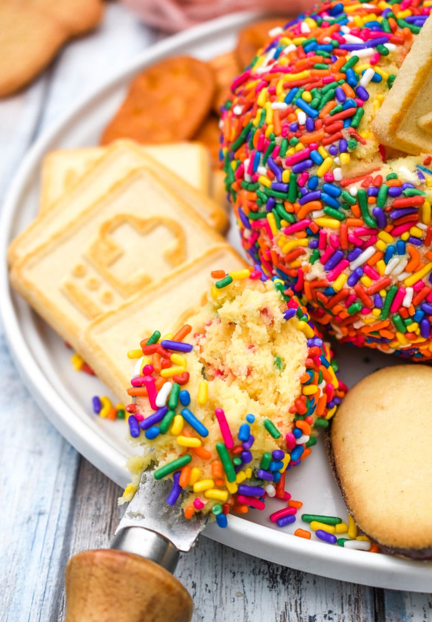 cake batter cheese ball dip spread on a lorna doone cookie resting on a white plate