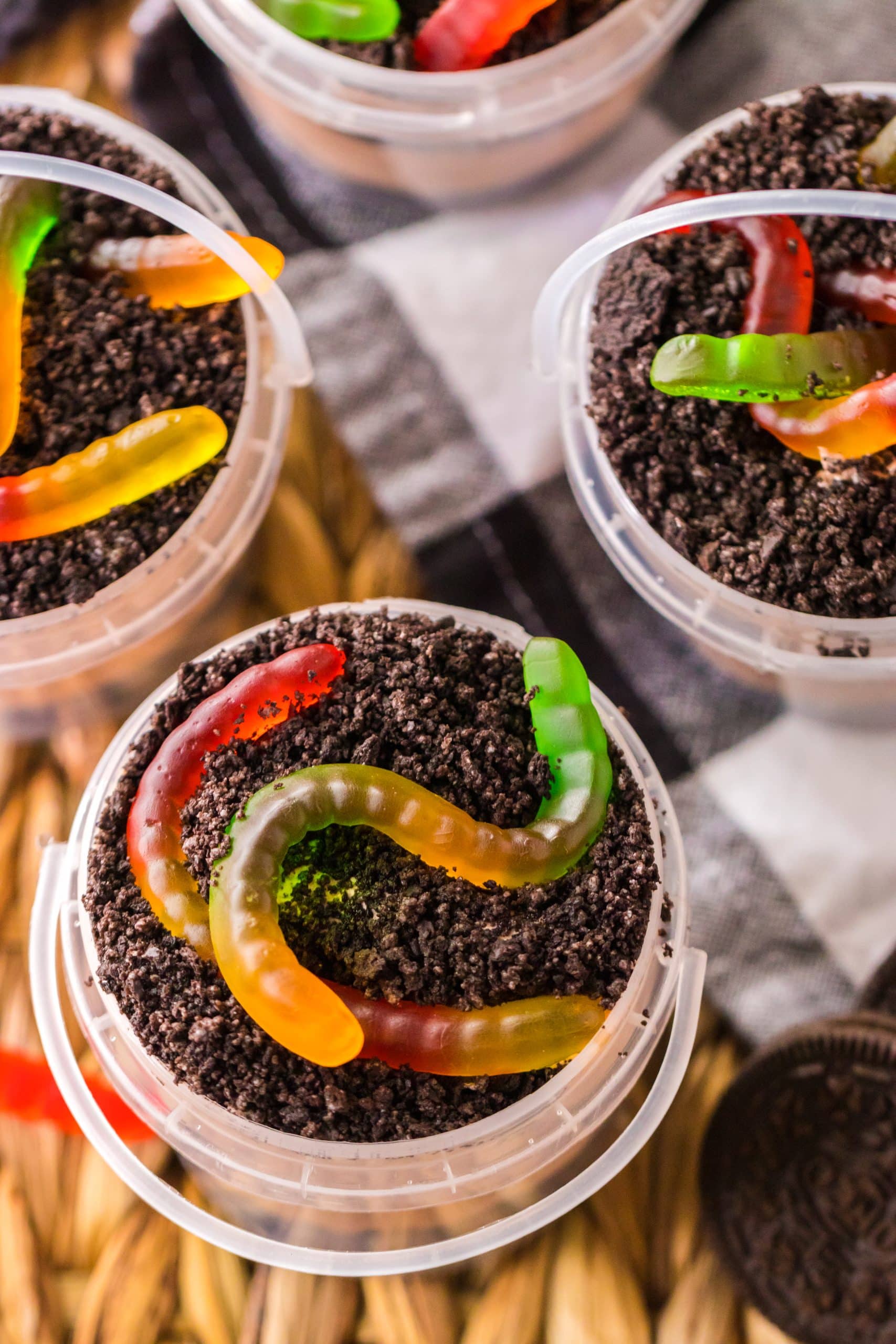 Summer Dirt Cake Cups in Buckets on a wicker placemat