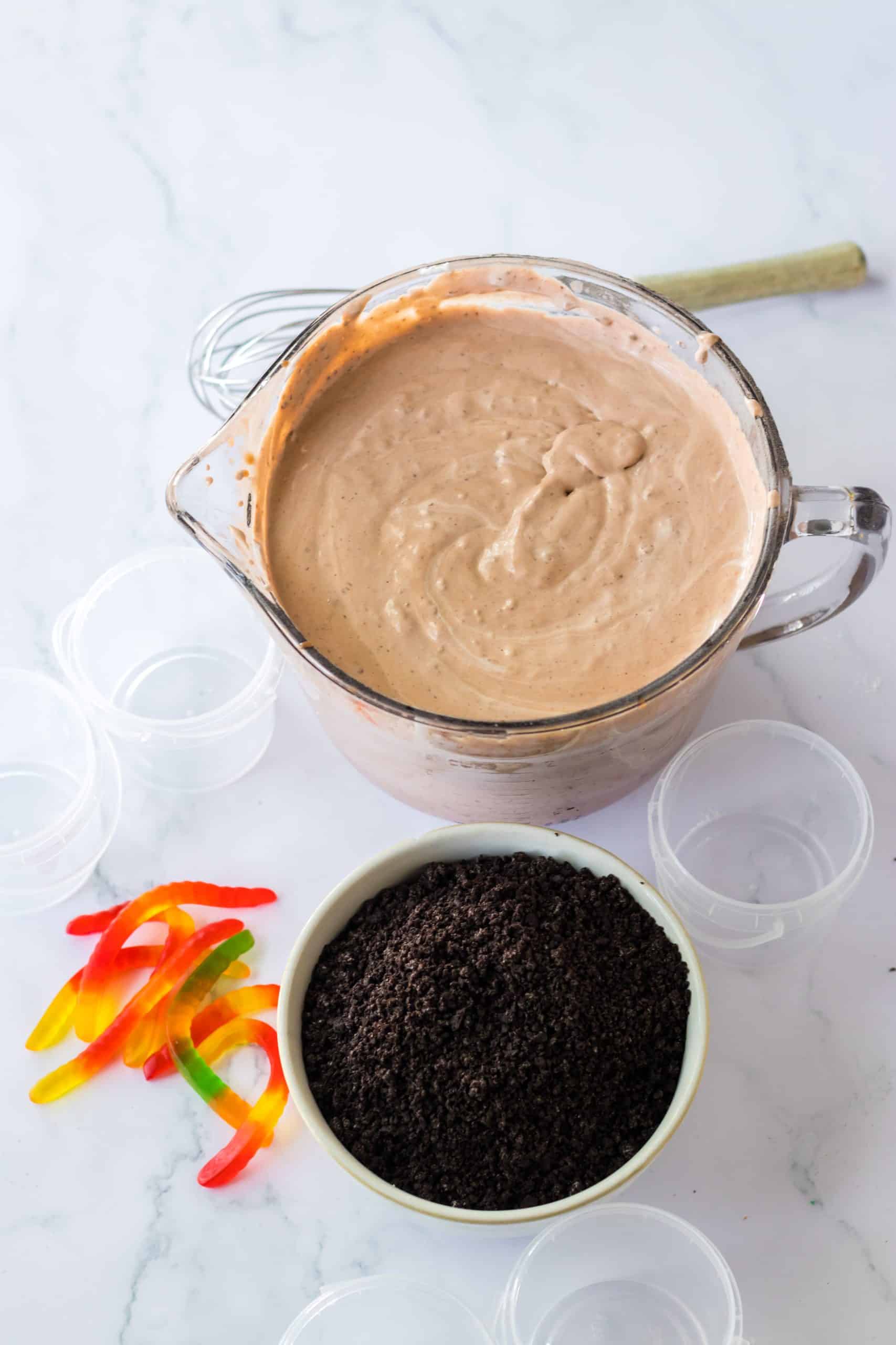 chocolate pudding in a glass bowl next to crushed oreos