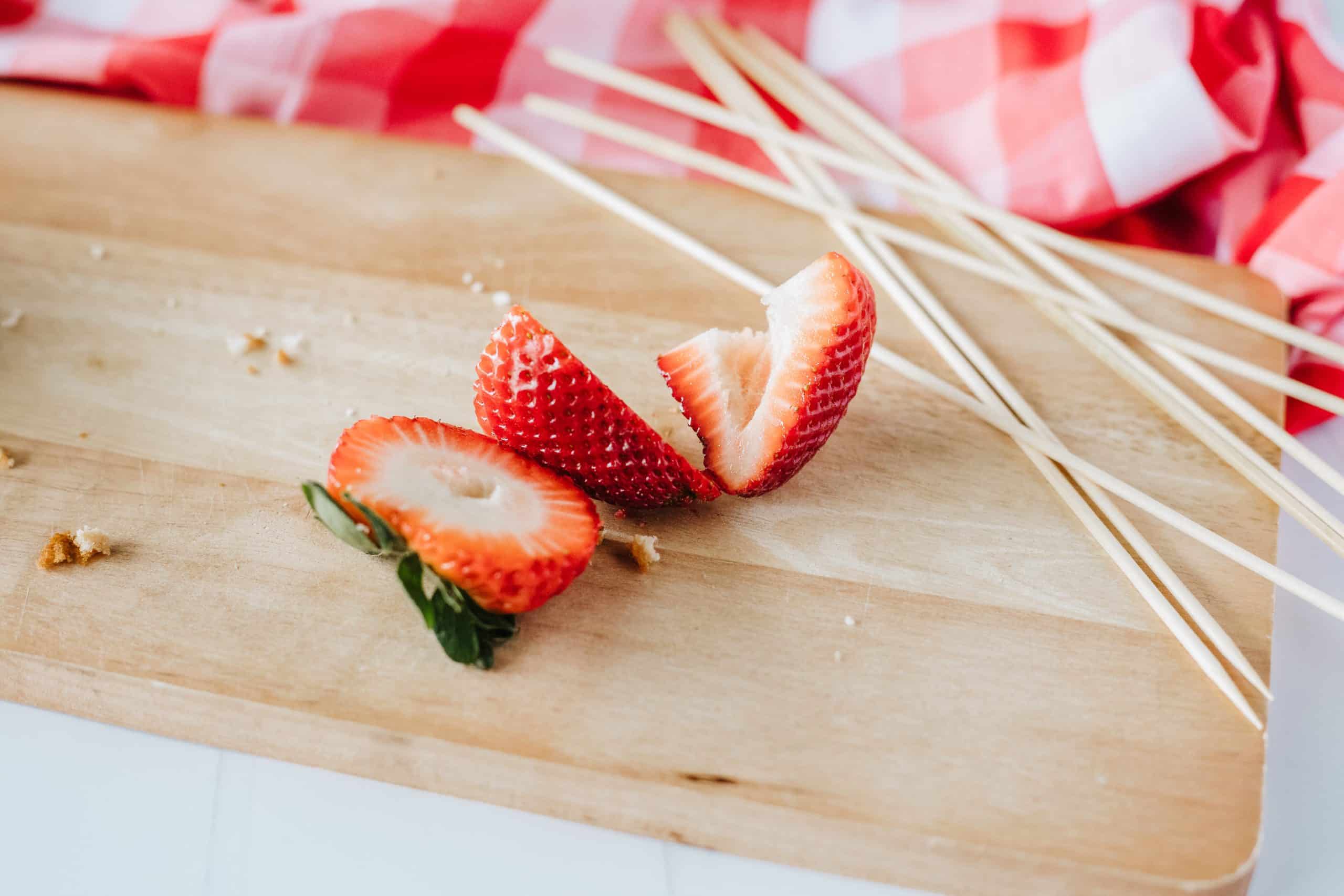 cut strawberry on a wooden cutting board