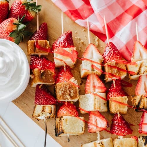 strawberry and pound cake skewers on a white platter