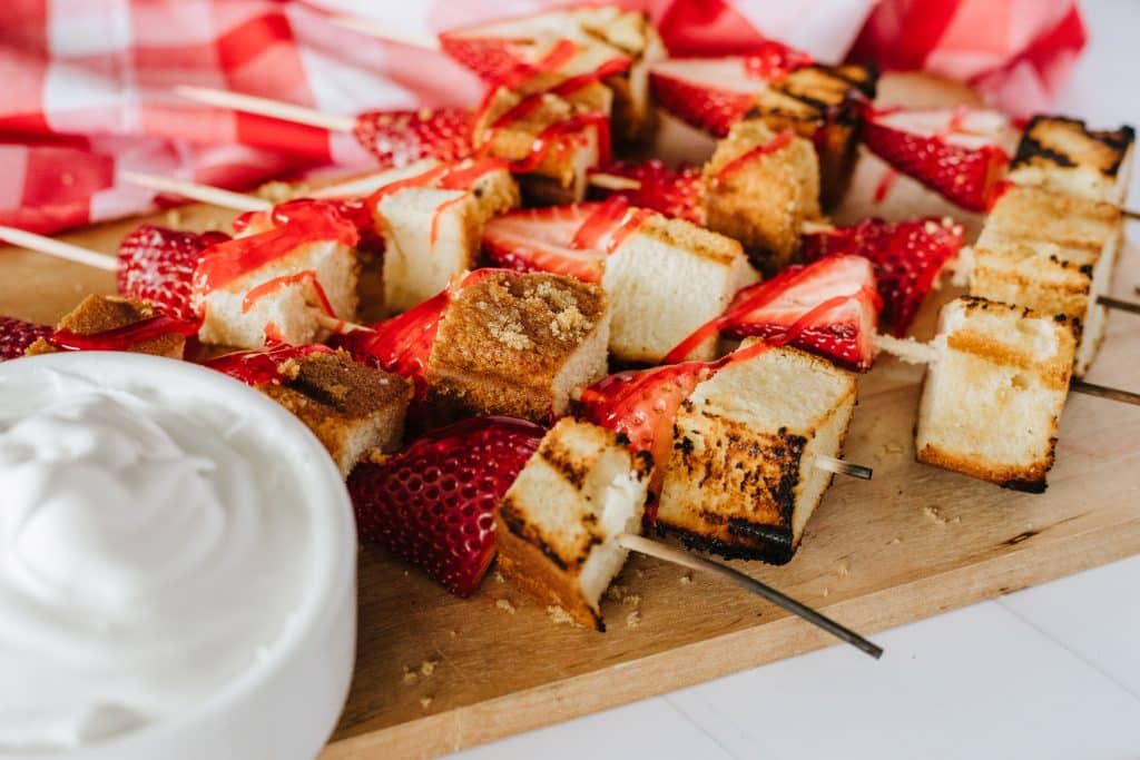 strawberry and pound cake skewers on a white platter