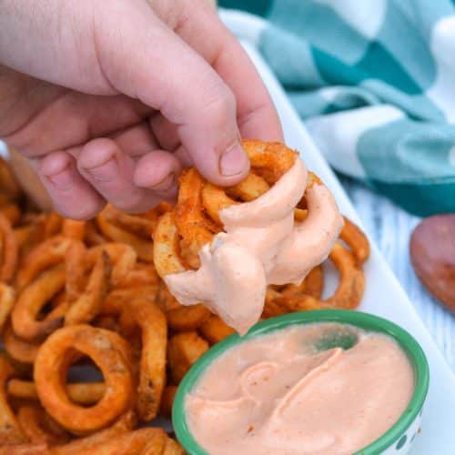 a hand holding up fries dipped in an easy comeback sauce recipe