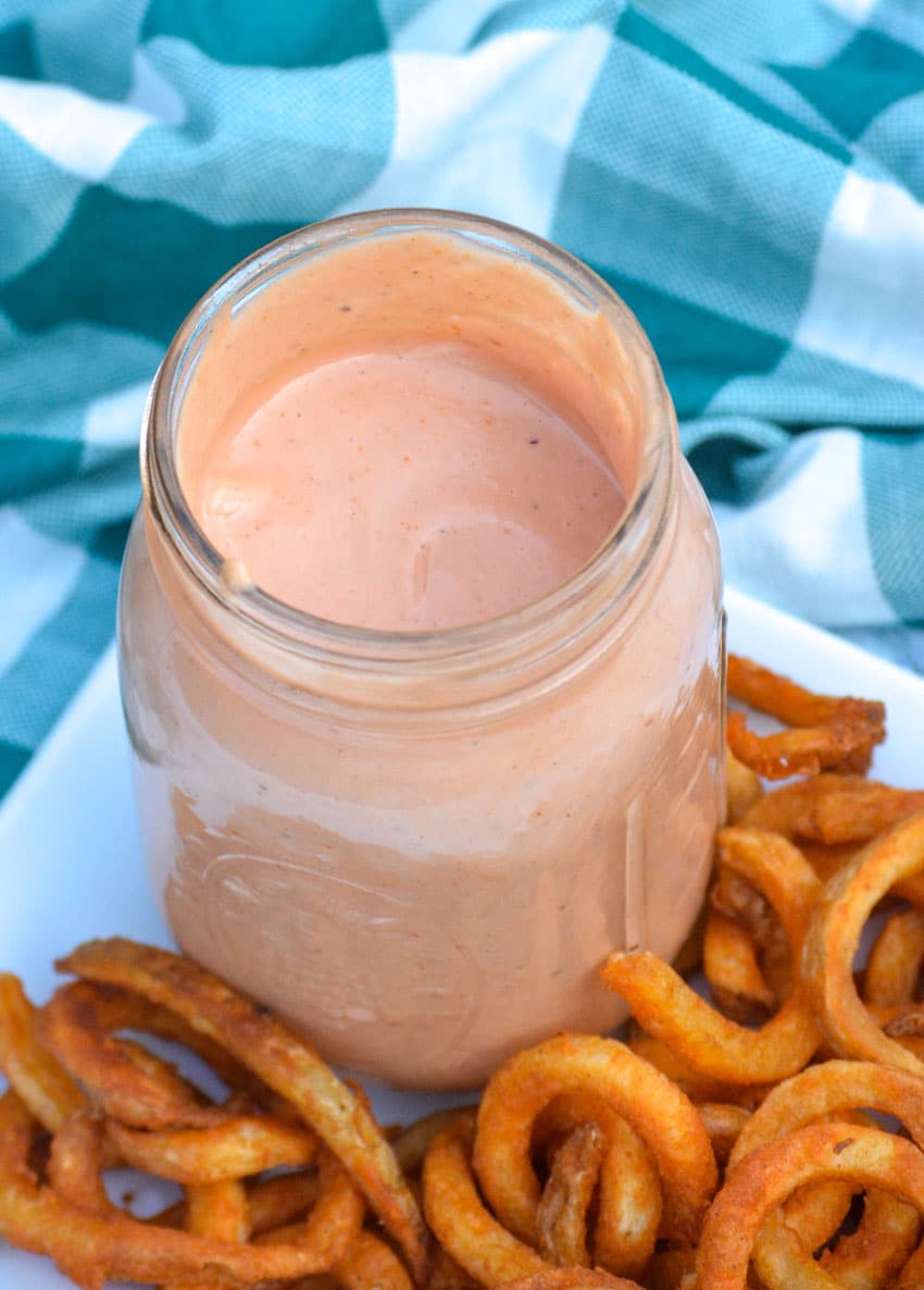 mississippi comeback sauce in a glass mason jar surrounded by crispy curly fries